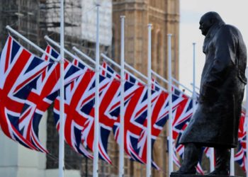 Image of the Churchill statue in Parliament square, flanked by Union flags, image by Kristina G on Unsplash