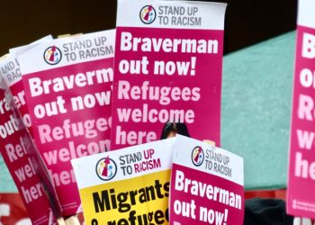 Placards saying "Braverman out now! Refugees welcome here"