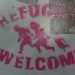 Sign on lamppost written in pink saying "refugees welcome"