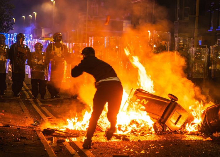 Southport, merseyside, UK, July 30th 2024, rioter throws brick at police line over fire