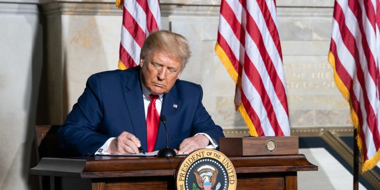 Donald Trump signing papers at the White House