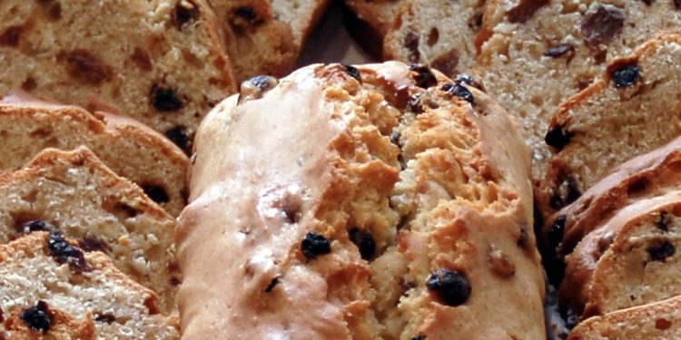 a close-up of a fruit loaf surrounded by cut slices of loaf