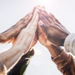 Abstract background. Hands of diverse people coming together in the concept of unity represent teamwork and cooperation.