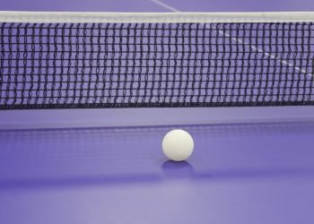 a close up of a table tennis table with net and ball
