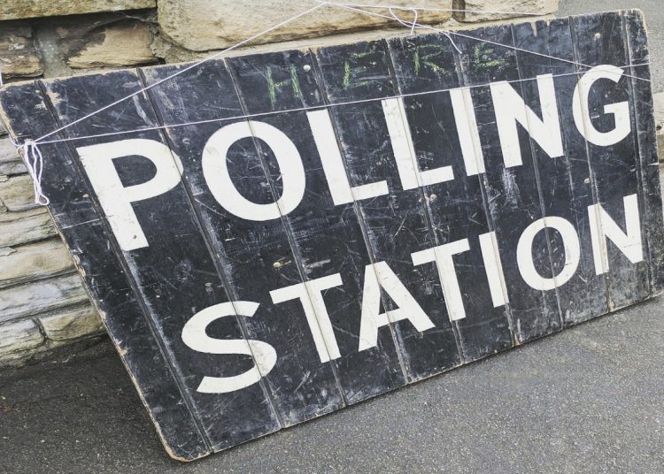 a large black sign with the words polling station printed in white