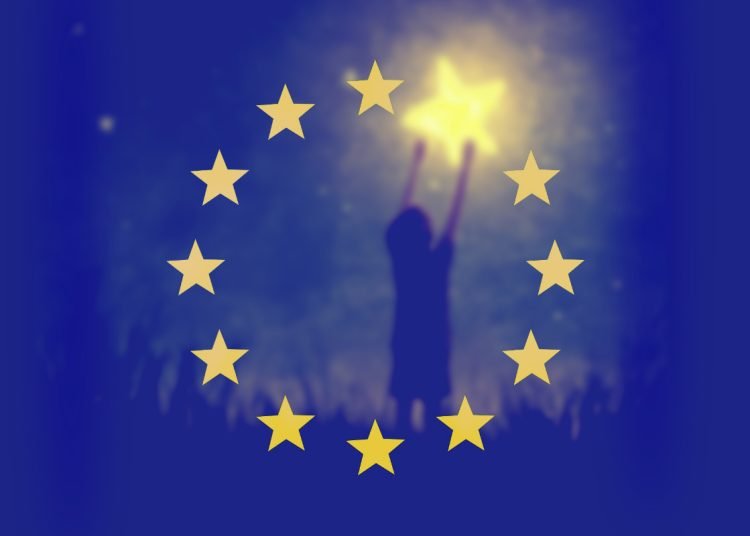 a small child reaches up holding a yellow star, which also forms one of the yellow stars of the European flag