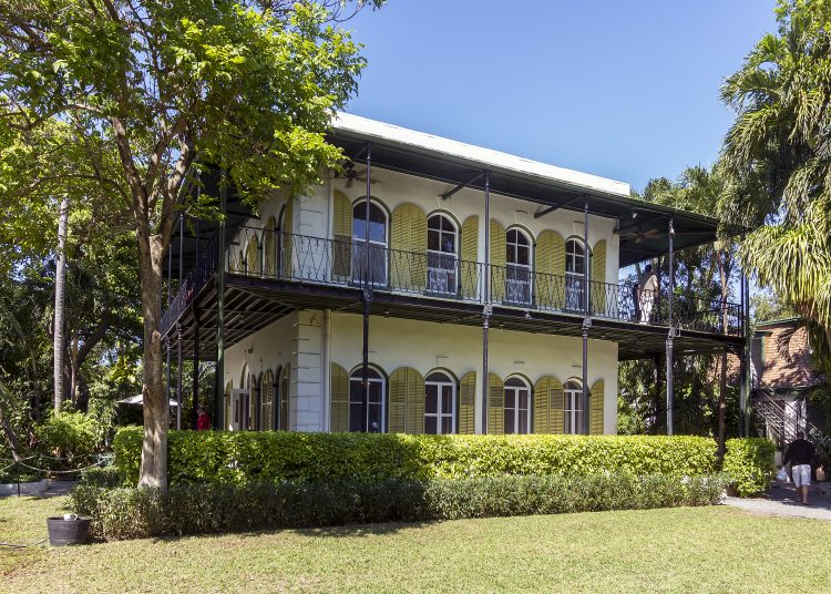 exterior of wooden house with green painted walls and a verandah, in the southern American style: it was novelist Ernest Hemingway’s home on Key West