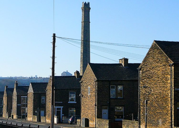Row of small Victorian houses in Halifax with a factory chimney behind them