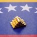 Gold bars or ingots as a tool for balance, financial investment, and savings. Backdrop of Venezuelan flag.