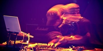 Electronic music performer, blurred to capture the motion.